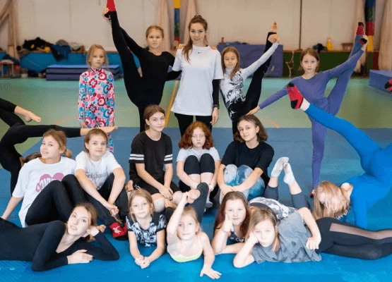 Юные спортсменки и их инструктор в спортивном зале
